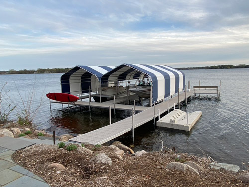 titan dock with navy and white striped boathouses on Lake Minnetonka